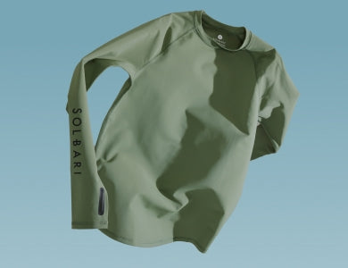 A light green top floating on a light blue background.