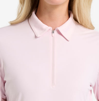 Close-up of a pink zip-up shirt worn by a person with blonde hair.