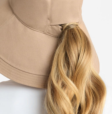 Beige hat with a blonde ponytail whole on a white background